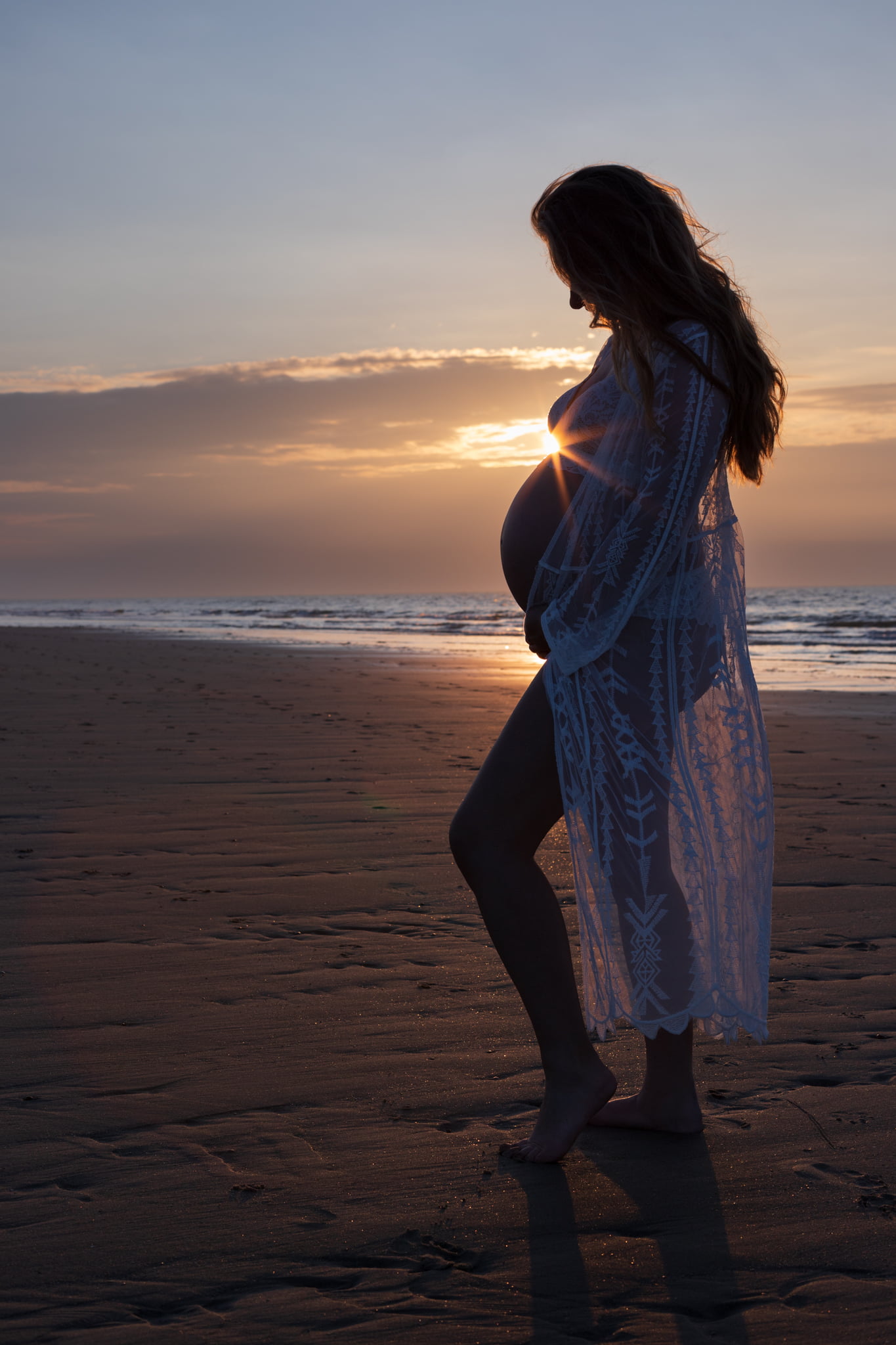 Zonsondergang zwanger strand foto